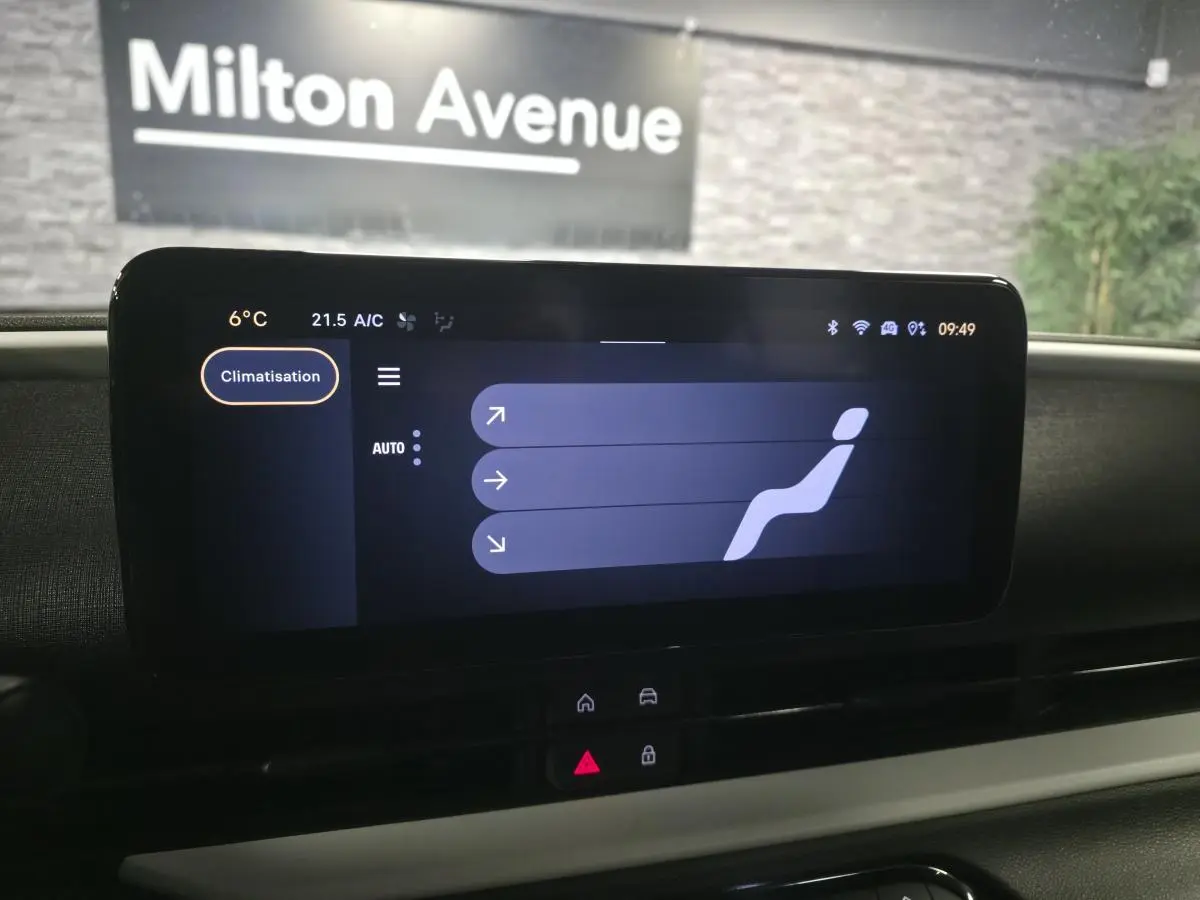 Écran tactile central de la Fiat 600 Hybrid 2024 affichant le réglage de la climatisation, vue intérieure frontale.