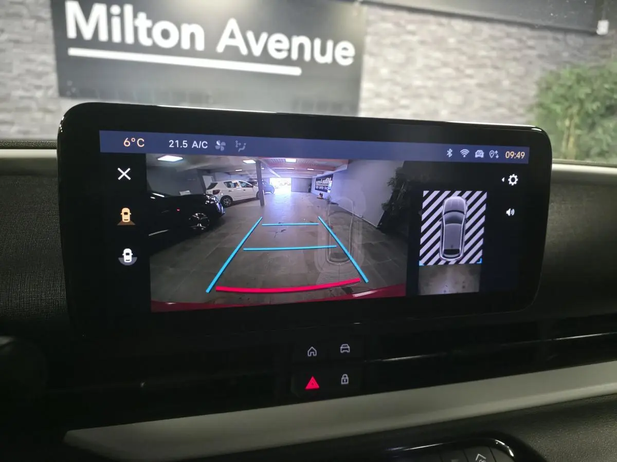 Écran tactile intérieur montrant la caméra de recul et l’aide au stationnement 360° du Fiat 600 rouge 2024.