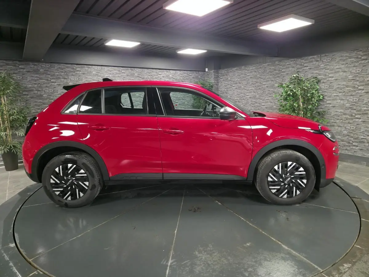 Vue latérale droite du FIAT 600 rouge 2024 avec jantes acier bicolores et coques de rétroviseurs noires.