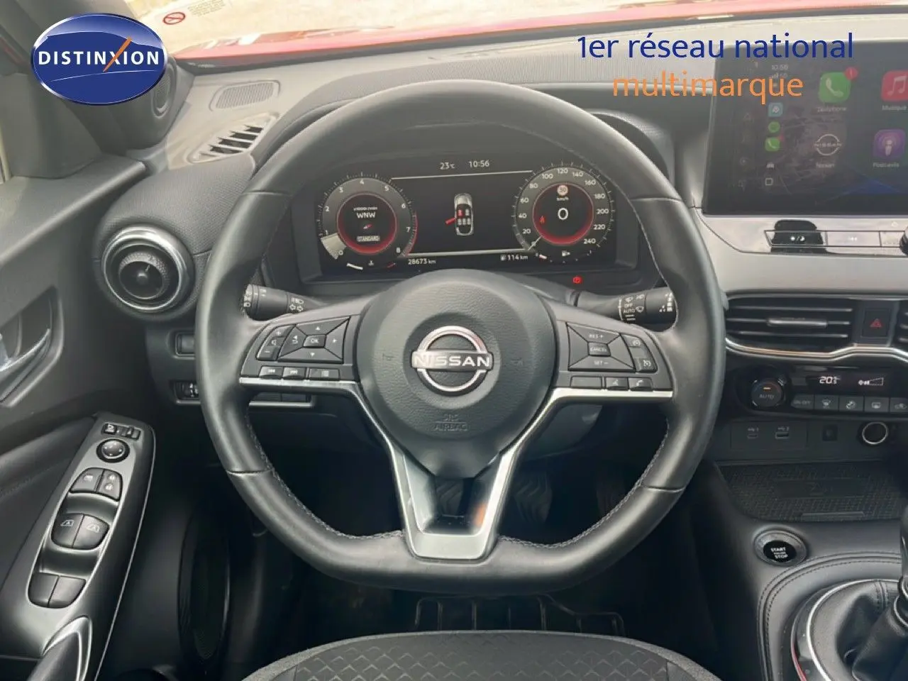 Vue intérieure centrée sur le volant cuir noir du Nissan Juke 2024 avec tableau de bord numérique et console moderne.