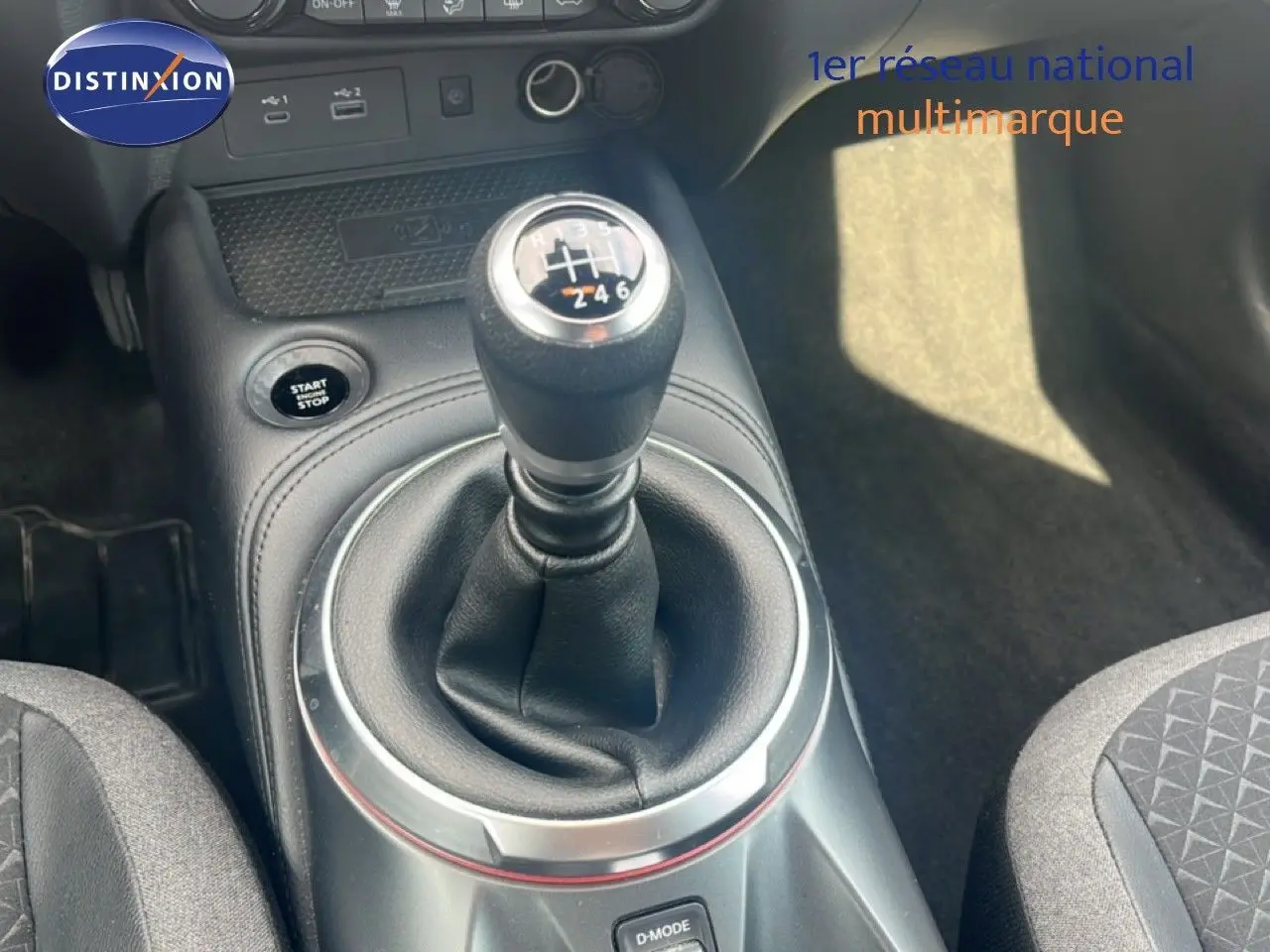 Le levier de vitesses manuel du Nissan Juke rouge Fuji Metal 2024 vu en gros plan dans l'habitacle.