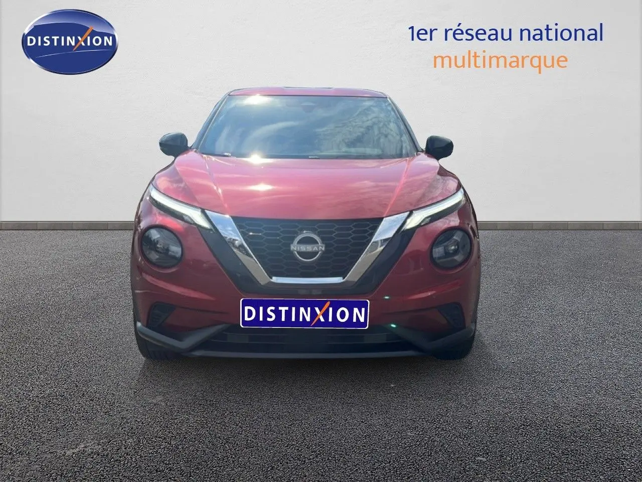 Vue frontale du Nissan Juke 2024 en rouge Fuji Metal avec calandre chromée et phares LED distinctifs.