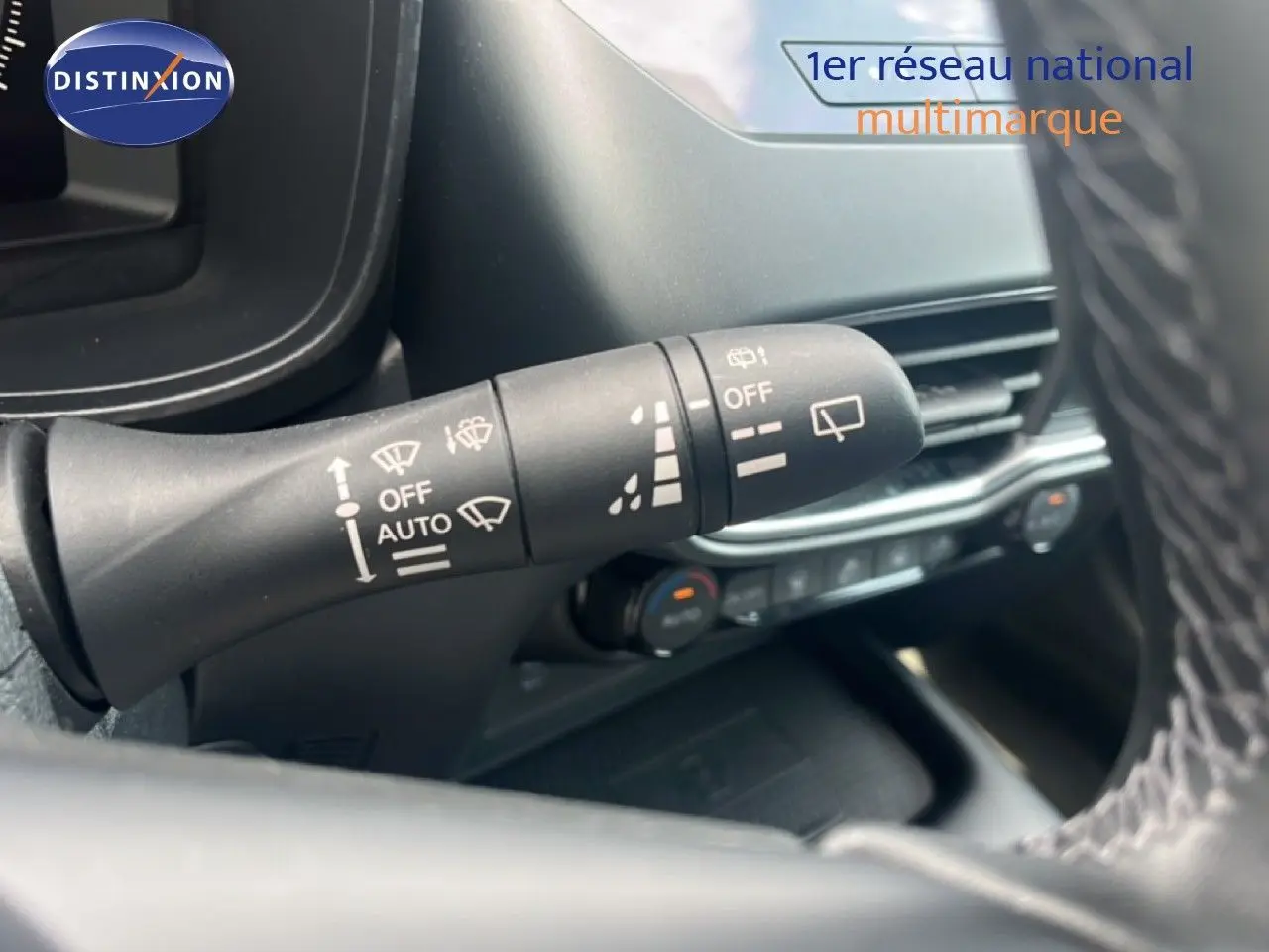Gros plan sur la commande d’essuie-glace à gauche du volant dans l’habitacle du Nissan Juke rouge Fuji Metal 2024.
