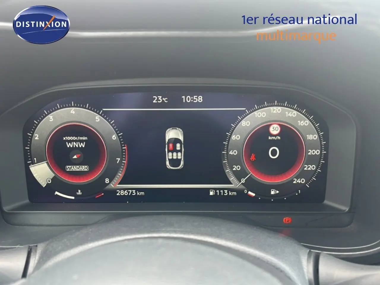 Vue rapprochée du tableau de bord numérique du Nissan Juke rouge Fuji Metal 2024, affichant compte-tours et vitesse.