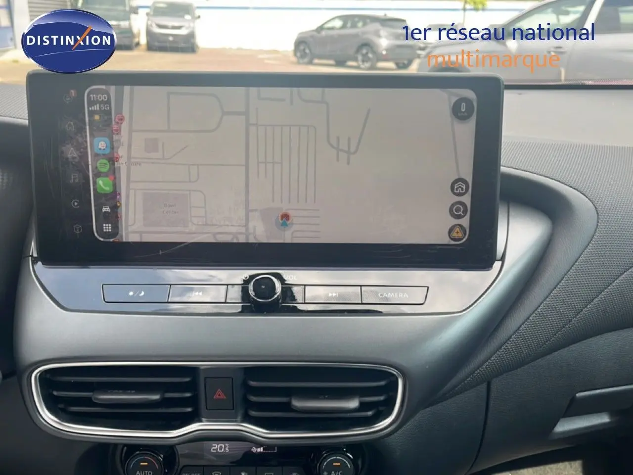 Vue rapprochée de l’écran tactile central et de la console du Nissan Juke rouge Fuji Metal 2024, mettant en valeur l’interface de navigation.