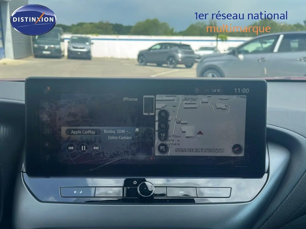 Vue intérieure centrée sur l’écran tactile du tableau de bord du Nissan Juke rouge Fuji Metal 2024, affichant la navigation.