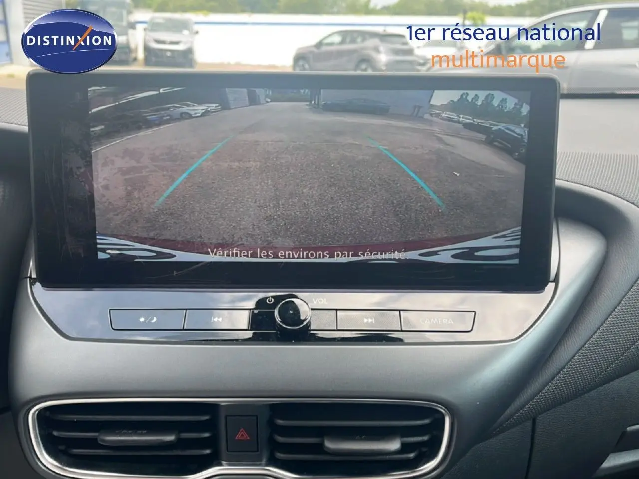 Écran central montrant l’image de la caméra de recul du Nissan Juke rouge Fuji Metal, vue de l’intérieur avant.
