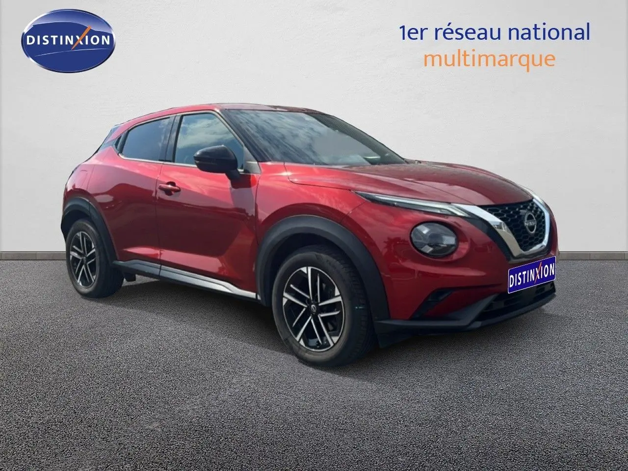 Nissan Juke rouge Fuji Metal en 3/4 avant droit, mettant en valeur ses jantes noires et son design compact.
