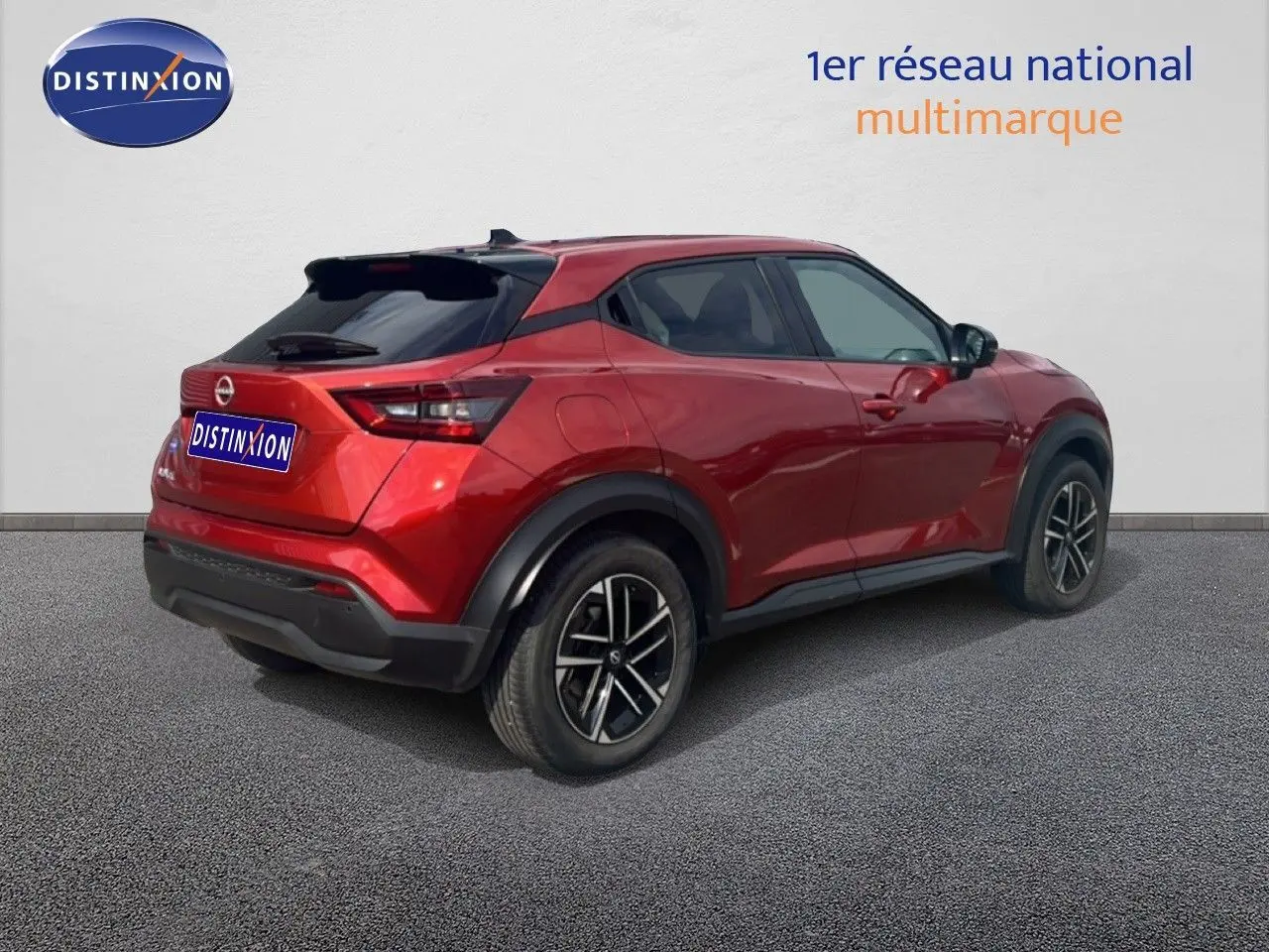 Nissan Juke rouge Fuji Metal vu en 3/4 arrière droit, avec jantes noires et détails noirs contrastants.