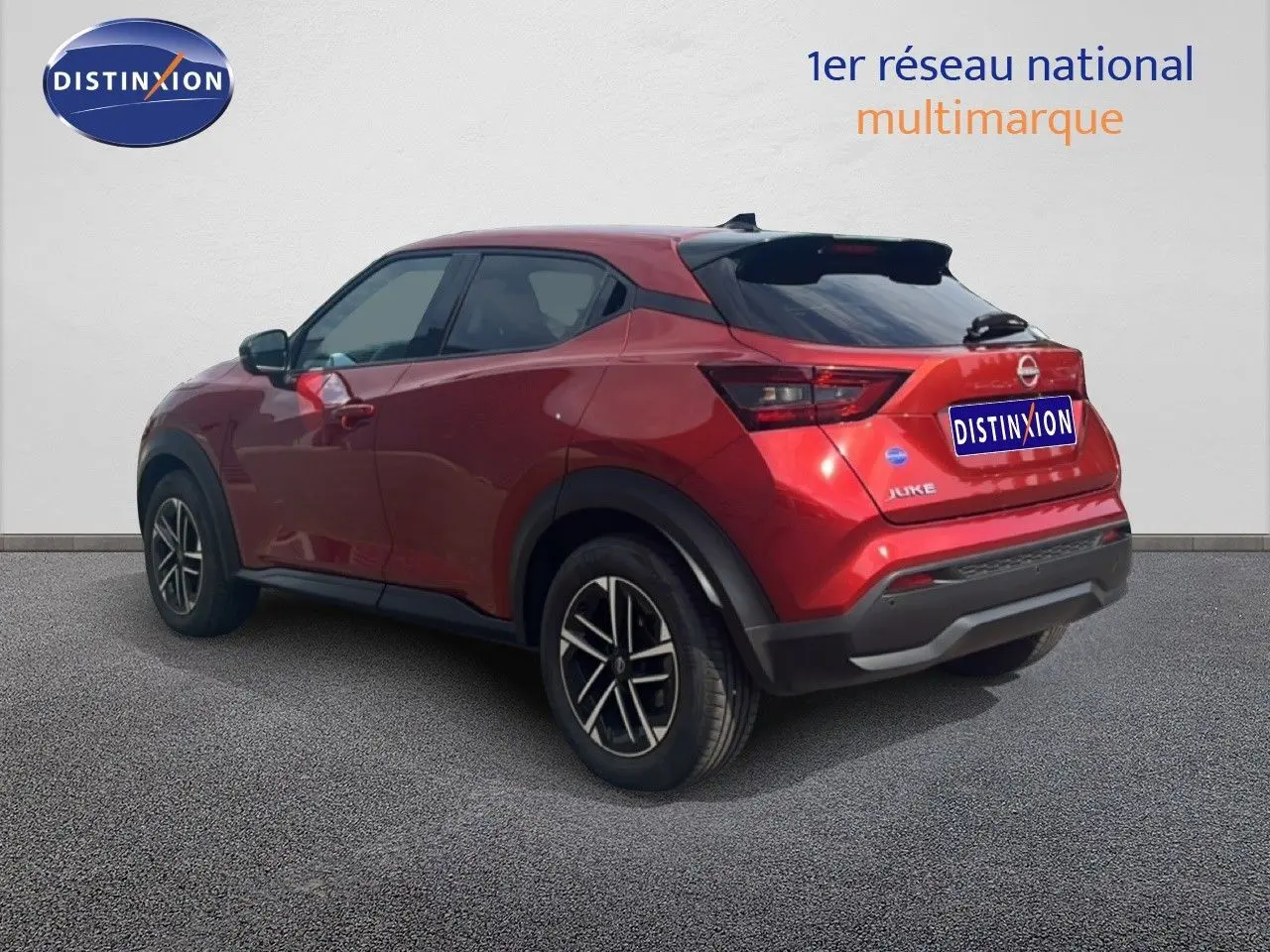 Nissan Juke rouge Fuji Metal en 3/4 arrière droit, avec jantes alliage et toit noir contrasté.