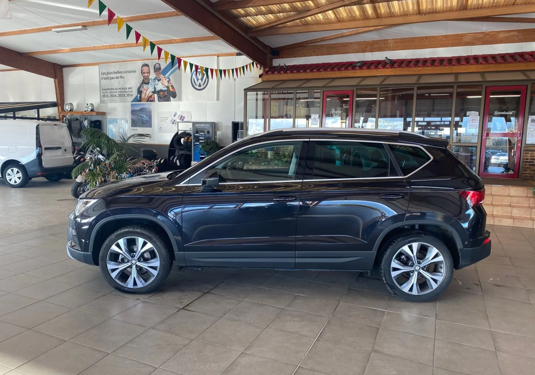 Vue latérale droite d'un SEAT Ateca Urban noir 2019 en intérieur, soulignant ses jantes alliage et lignes élégantes.