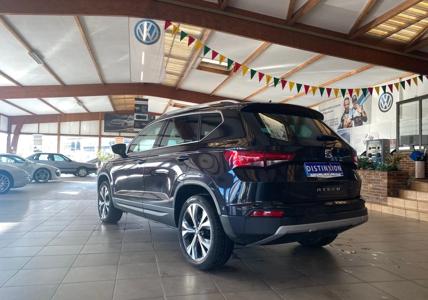 SEAT Ateca Urban noir vue 3/4 arrière droit en intérieur, avec jantes alliage et feux arrière allumés.