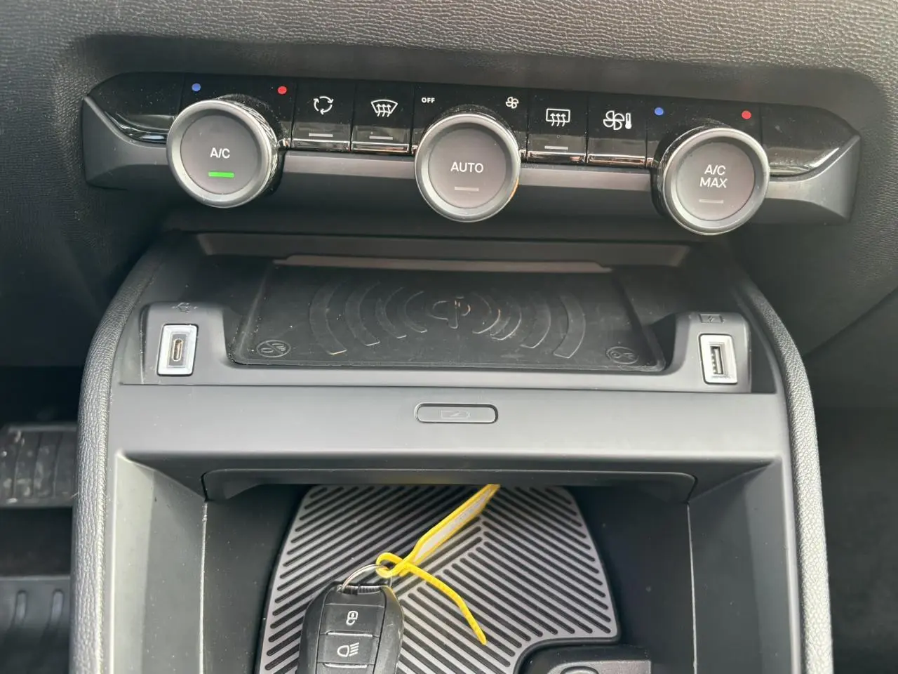 Détail de la console centrale de la Citroën C4 2024 avec commandes climatisation et zone de recharge sans fil.