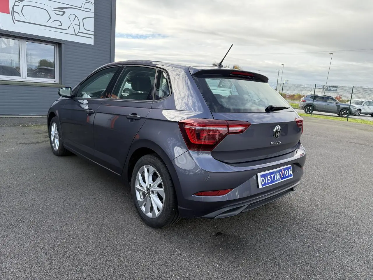 Volkswagen Polo gris cendre vue 3/4 arrière droit, feux arrière LED et jantes alliage visibles.