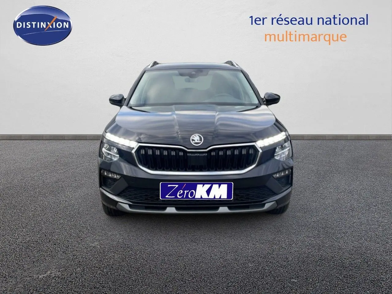 Vue frontale d'un Skoda Kamiq noir magique métal 2025 avec calandre distinctive et feux LED allumés.