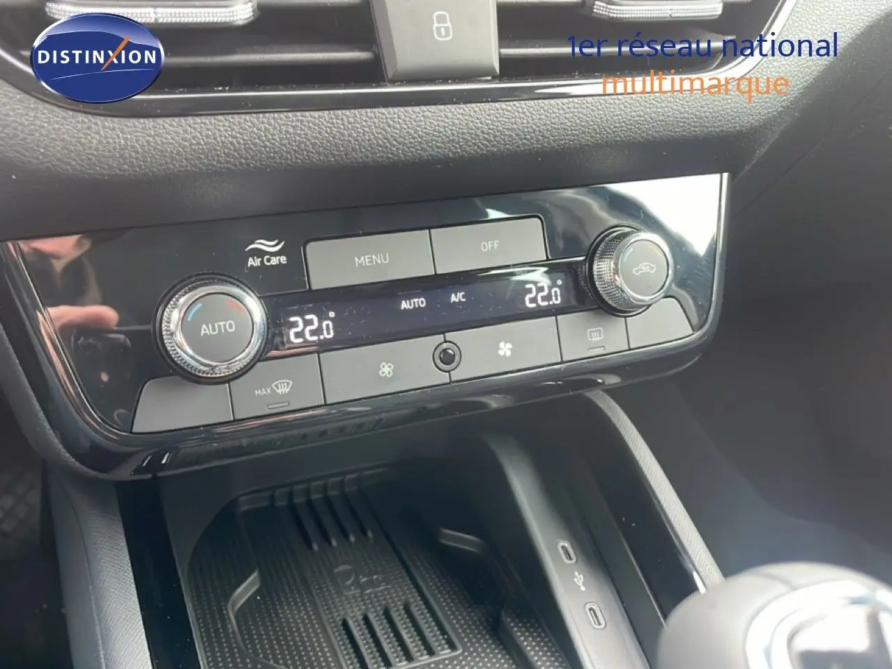 Vue rapprochée de la console centrale noire brillante du Skoda Kamiq 2025, avec commandes de climatisation digitale.