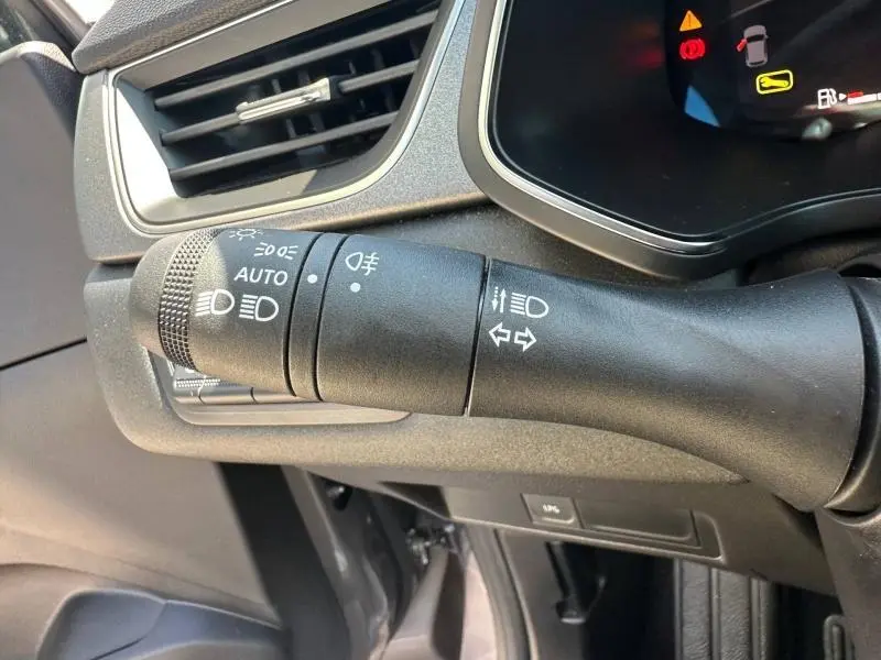 Gros plan sur la commande des phares et clignotants du Renault Captur gris Cassiopée métallisé, intérieur noir.
