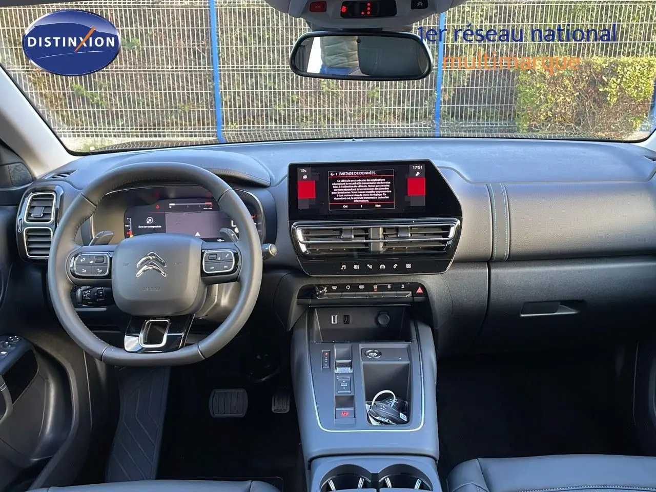 Vue intérieure avant du Citroën C5 Aircross 2025 noir, montrant le tableau de bord et le volant multifonction.