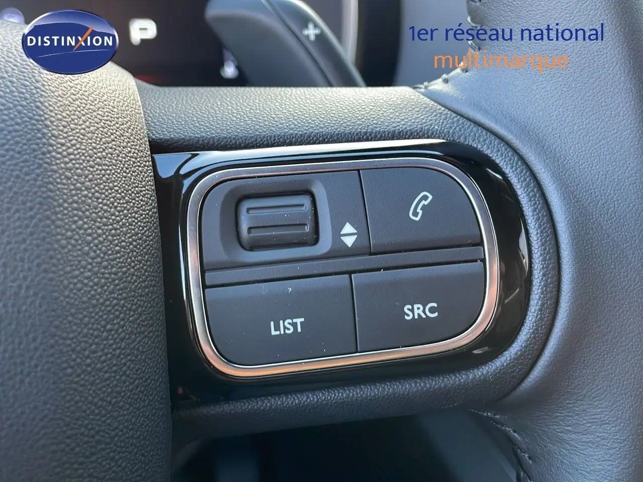 Gros plan sur les commandes au volant en cuir noir du Citroën C5 Aircross 2025, boutons LIST et SRC visibles.