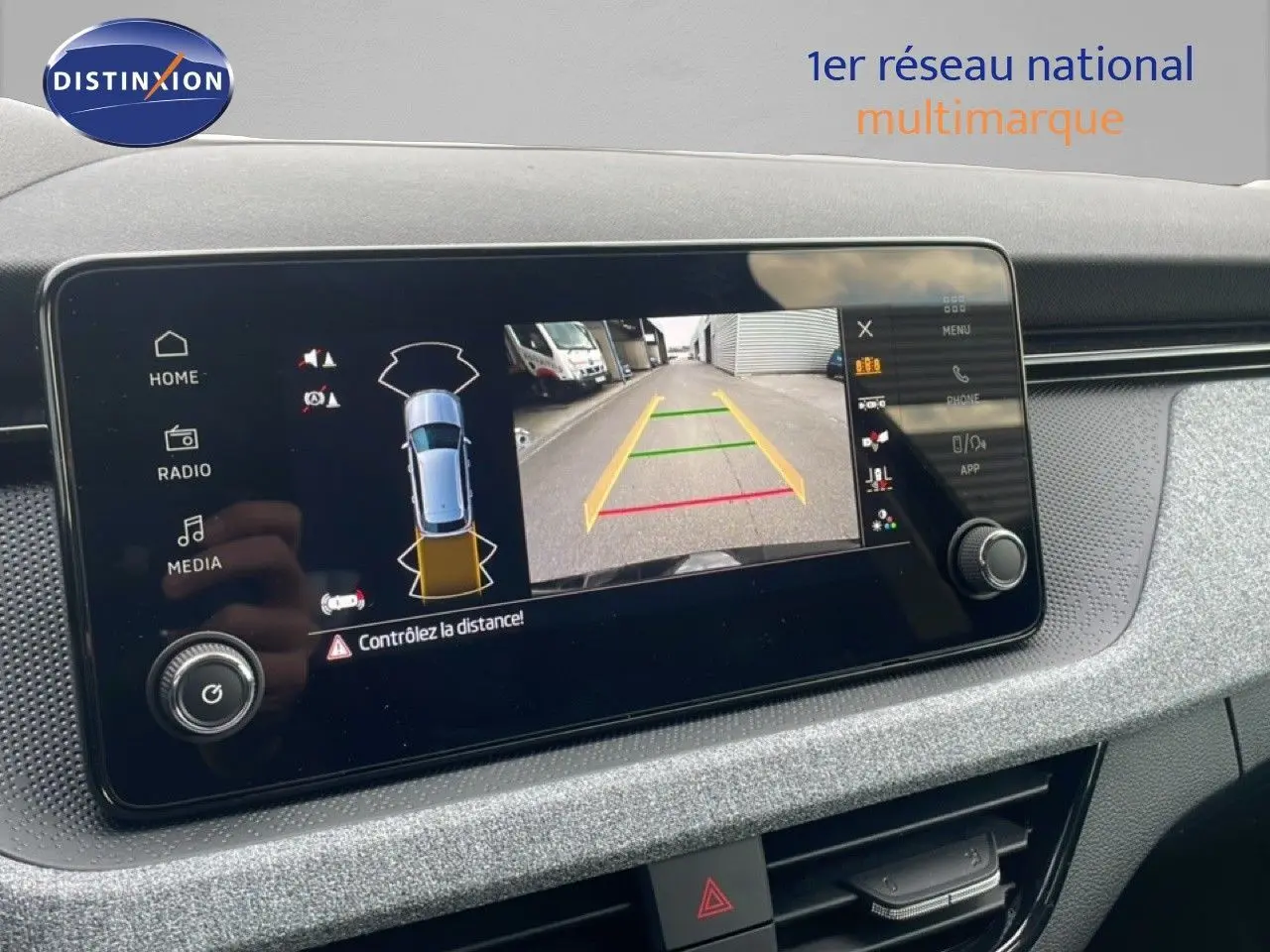 Écran tactile intérieur du Skoda Kamiq 2025 montrant la caméra de recul et l'alerte de distance en mode stationnement.