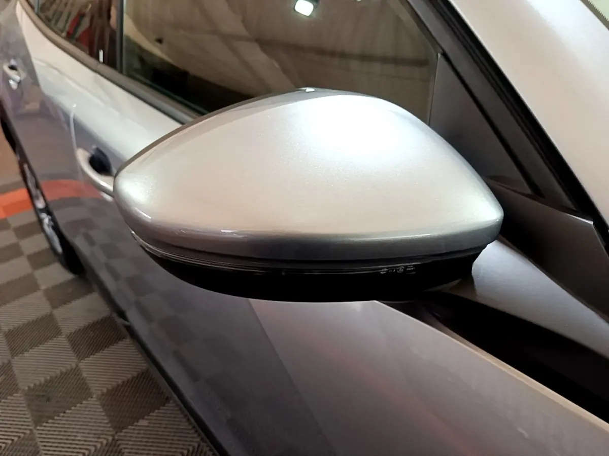 Gros plan sur le rétroviseur côté gauche gris clair du Peugeot 2008 PureTech 2021, avec carrosserie visible en arrière-plan.