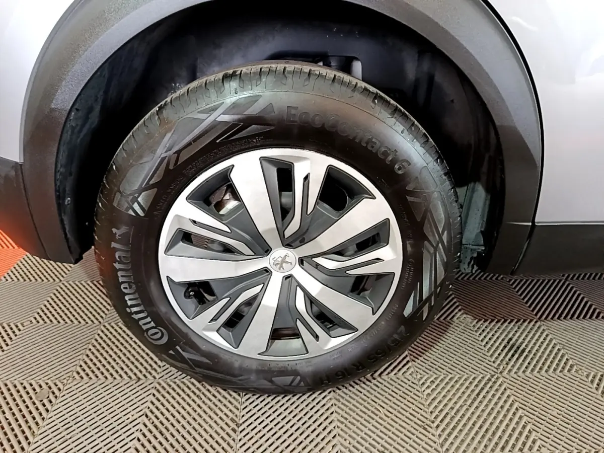 Gros plan sur la roue avant droite d’un Peugeot 2008 gris clair avec jante en alliage et pneu Continental.