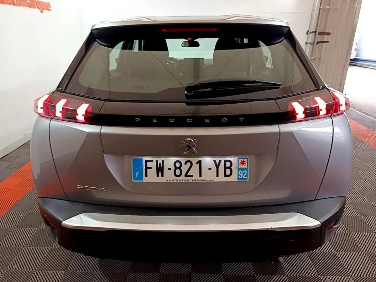 Vue arrière d’un Peugeot 2008 gris clair avec feux LED distinctifs et logo au centre du hayon.