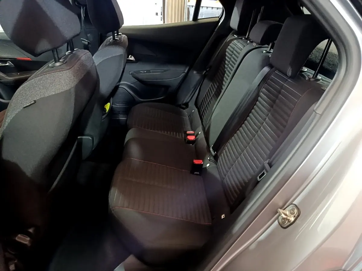 Vue intérieure côté droit des sièges arrière noirs avec surpiqûres rouges du Peugeot 2008 gris clair de 2021.