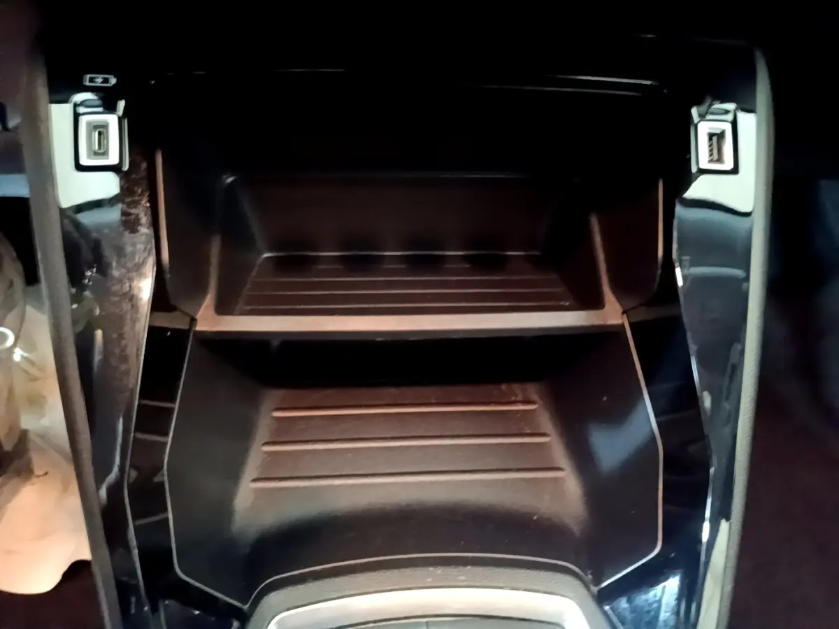 Gros plan sur le rangement central noir avec ports USB avant du Peugeot 2008 gris clair, version PureTech 100 S&S ACTIVE BUSINESS.