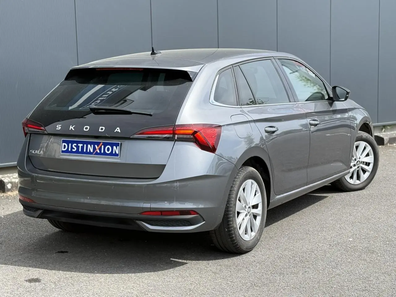 Vue 3/4 arrière droite d'une Skoda Scala gris graphite avec vitres surteintées et jantes alliage 16 pouces.