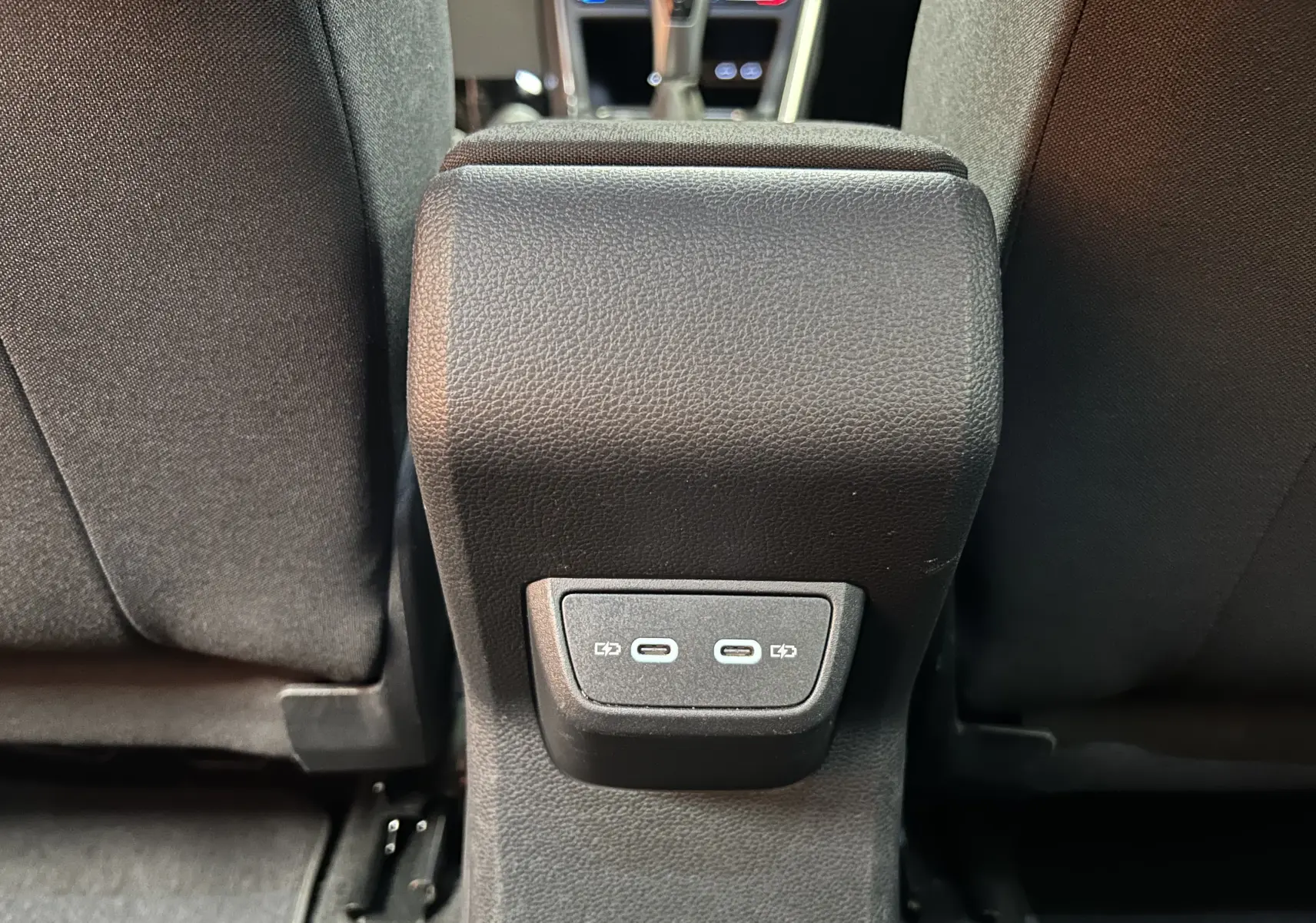 Prise USB-C double au dos de la console centrale entre les sièges arrière d'un Volkswagen Taigo blanc.