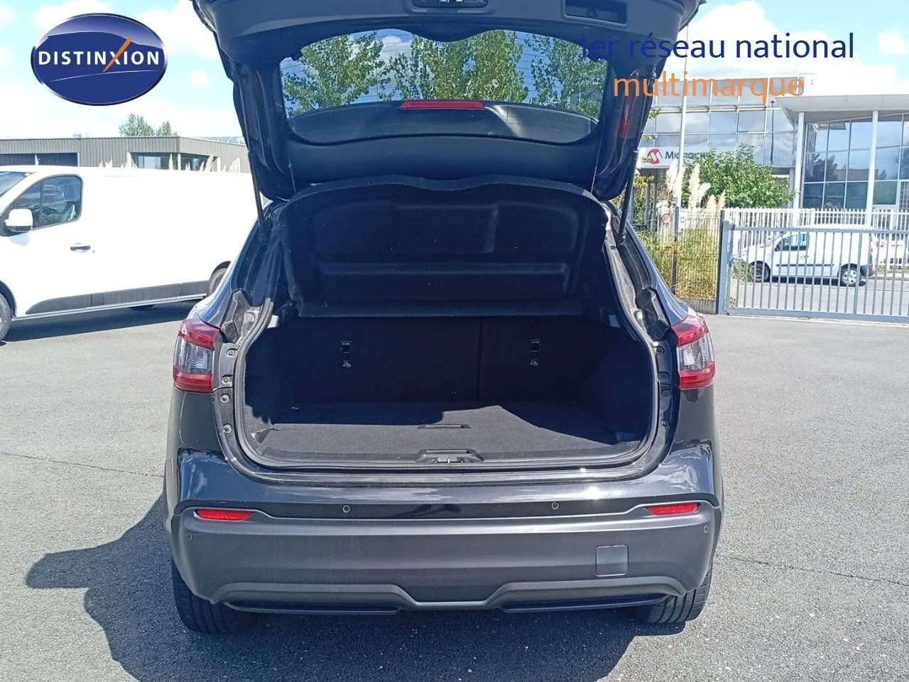 Vue arrière d'un Nissan Qashqai noir métal 2018 avec coffre ouvert, mettant en valeur l'espace de chargement.