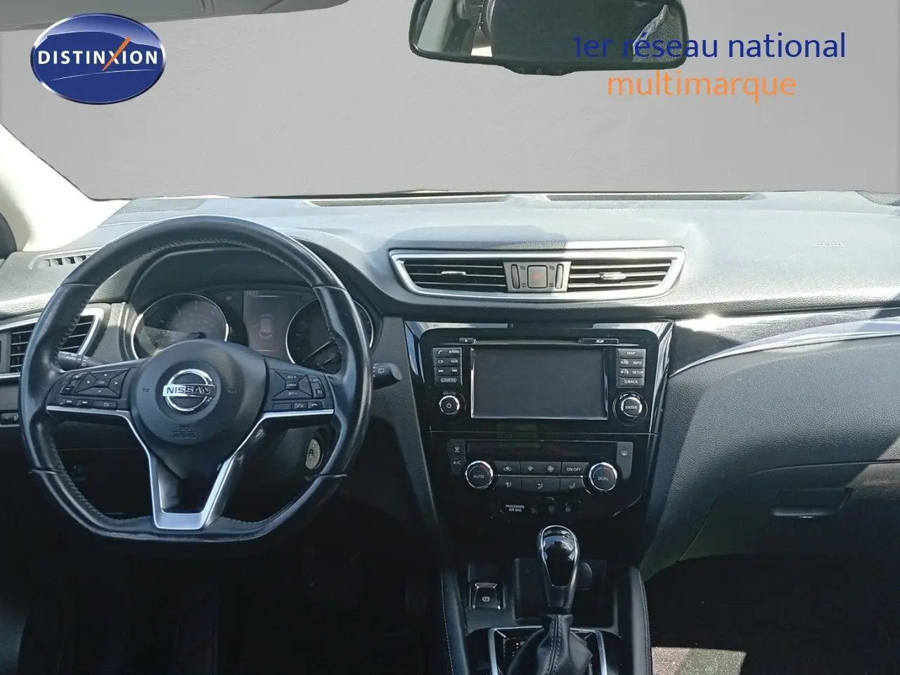 Vue frontale de l'intérieur noir du Nissan Qashqai 1.2 DIG-T 115ch Acenta Xtronic avec tableau de bord et volant multifonctions.
