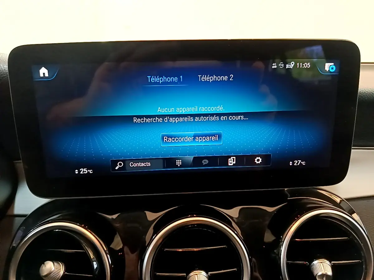 Écran tactile central affichant la connexion Bluetooth, entouré de trois aérateurs ronds chromés sur tableau de bord noir.
