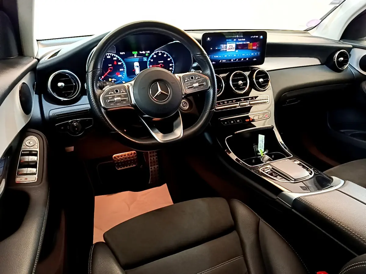 Intérieur avant de la Mercedes GLC 300 E AMG Line 2021, tableau de bord moderne avec écran tactile et volant cuir noir.