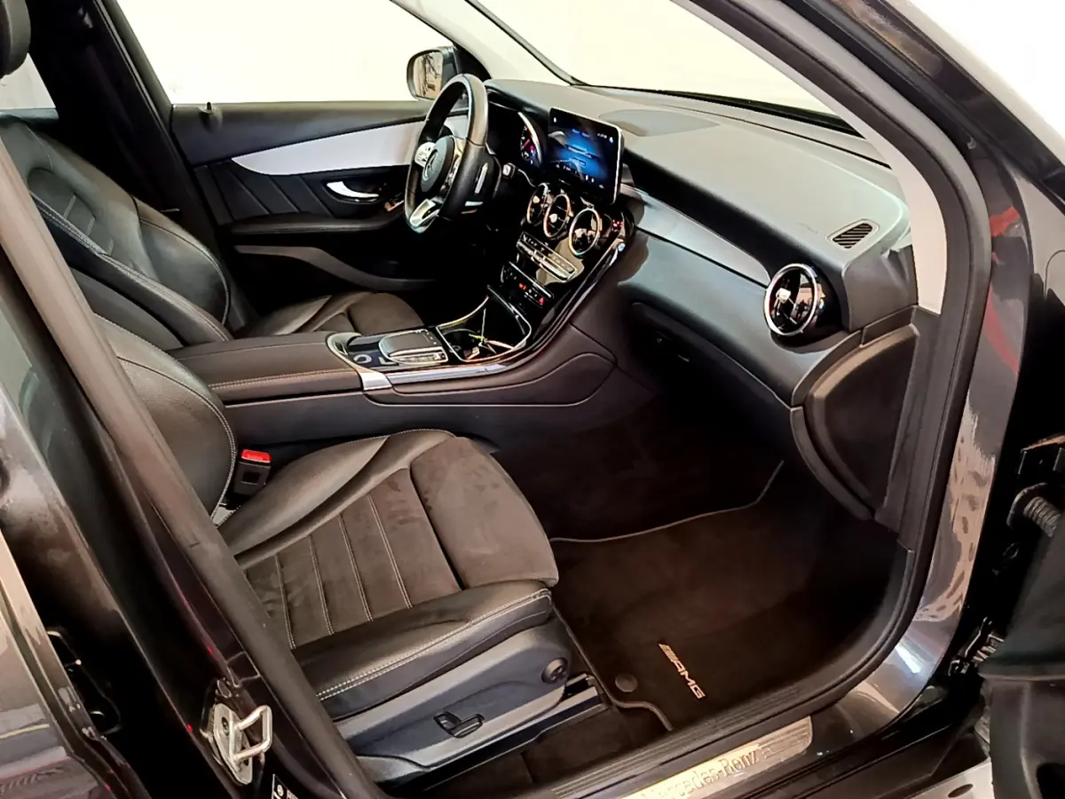 Intérieur côté conducteur du Mercedes GLC 300 E AMG Line 2021, sièges cuir noirs et tableau de bord moderne avec écran tactile.