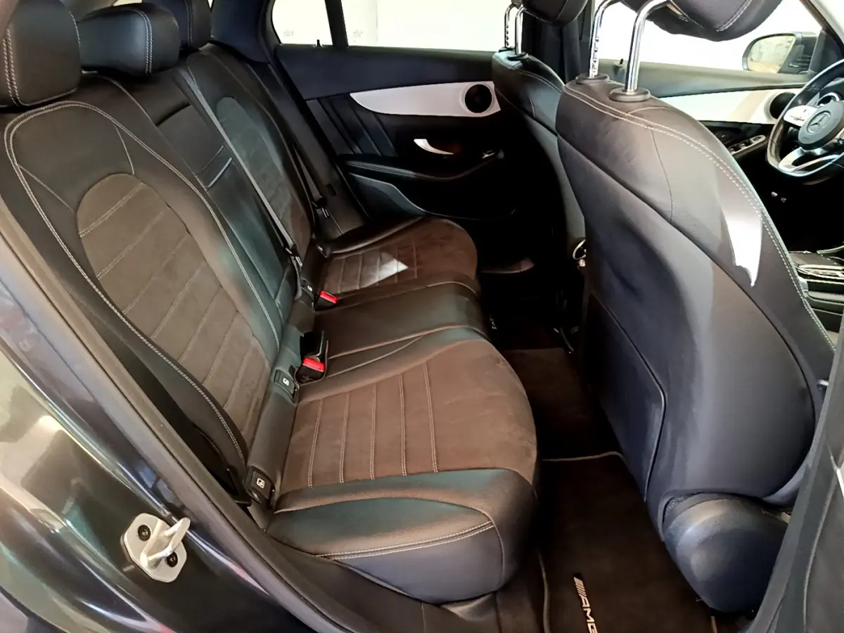 Vue intérieure côté gauche des sièges arrière en cuir noir et alcantara du Mercedes GLC 300 E AMG Line gris foncé 2021.