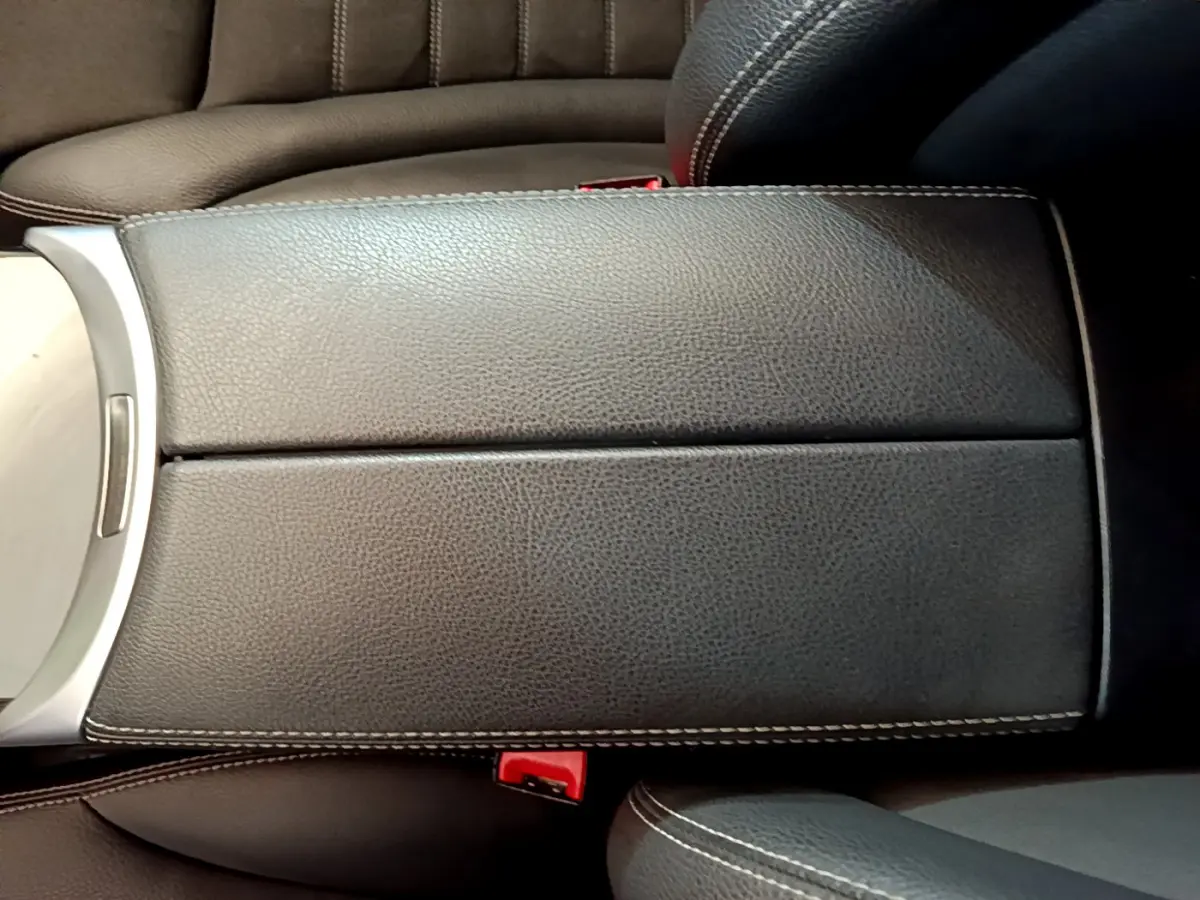 Accoudoir central en cuir noir avec surpiqûres blanches dans l'habitacle d'un Mercedes GLC 300 E AMG Line 2021.