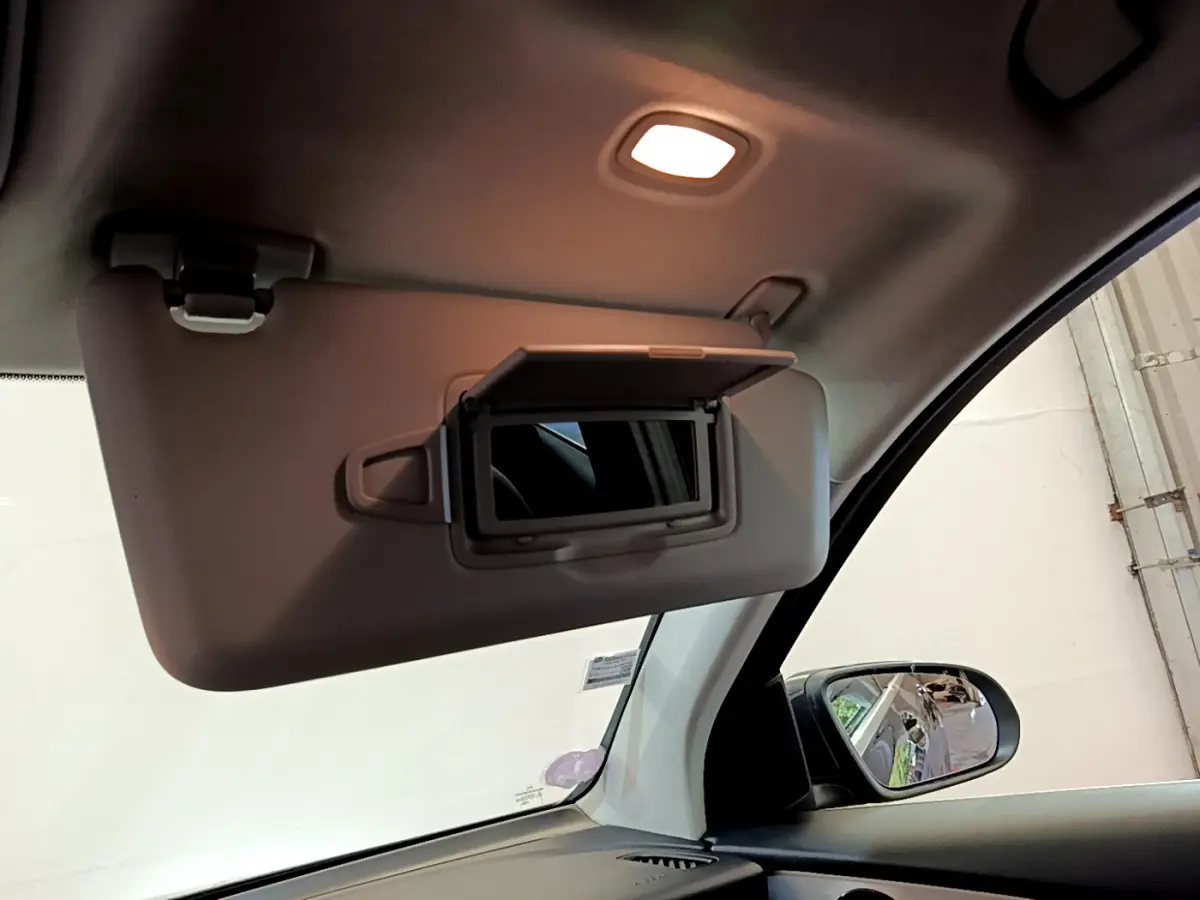 Miroir de courtoisie ouvert côté conducteur dans l'habitacle clair d'un Mercedes GLC 300 E AMG Line gris foncé 2021.