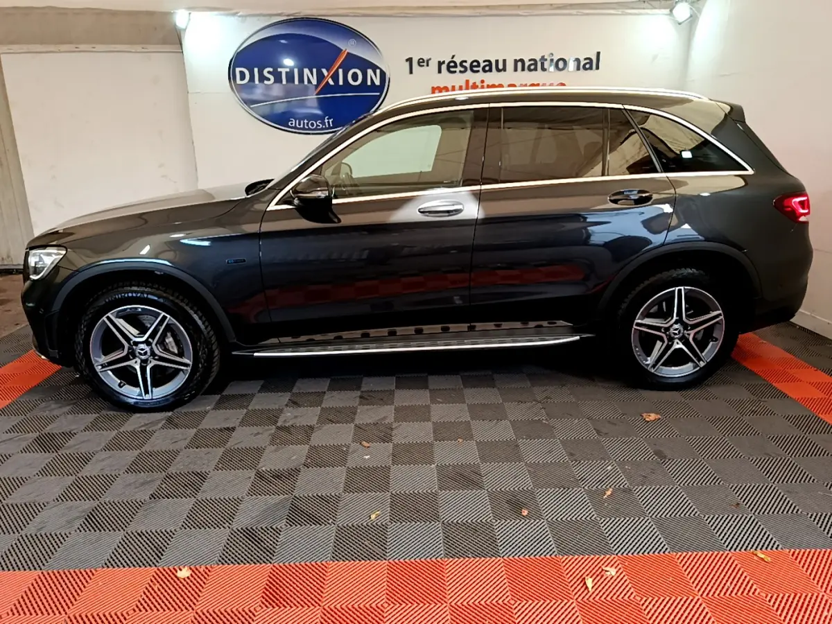 Profil côté gauche d'un Mercedes GLC 300 E AMG Line gris foncé avec jantes alliage et toit panoramique.