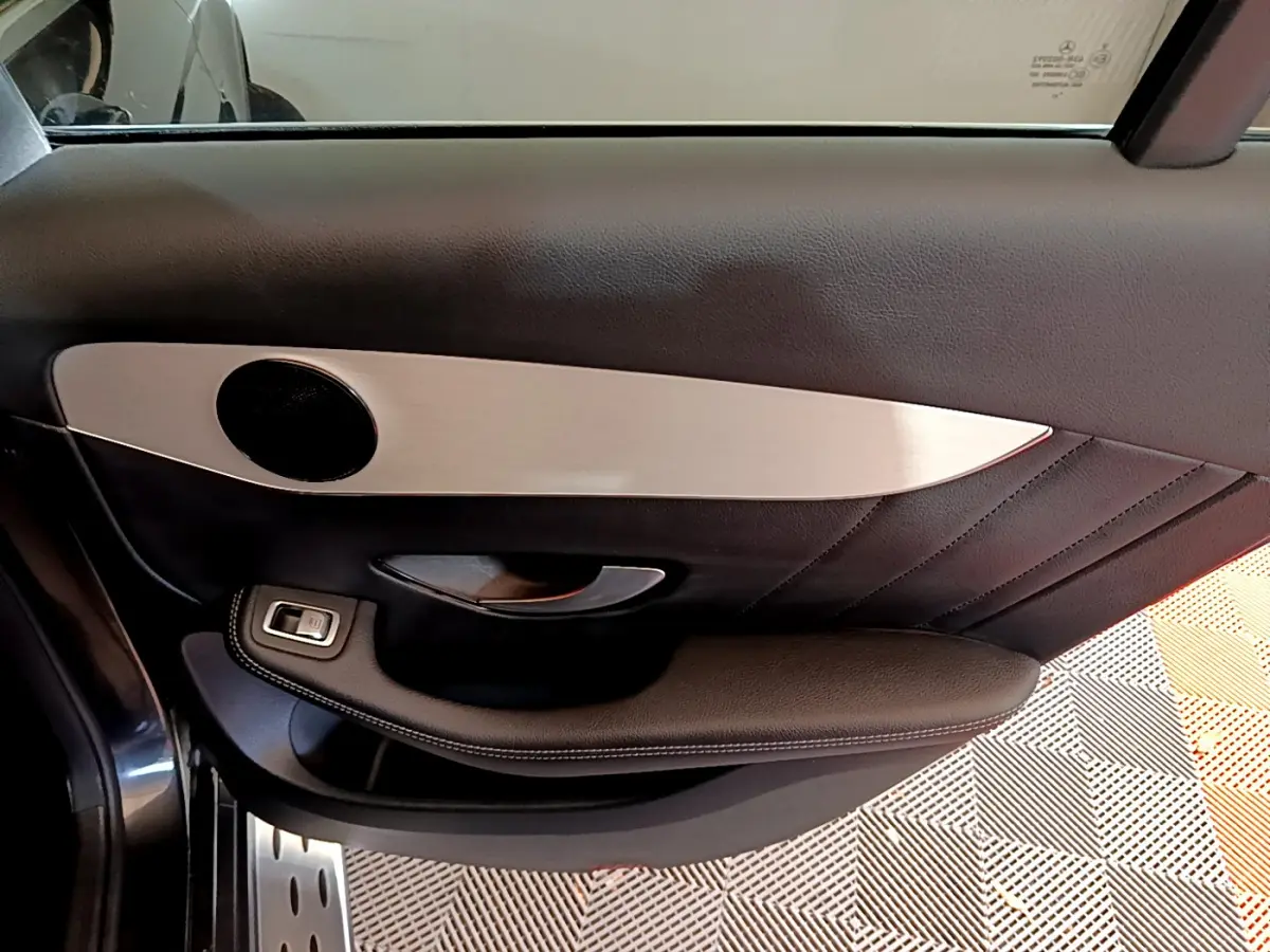 Gros plan sur la porte intérieure côté gauche d'une Mercedes GLC 300 E AMG Line 2021 avec garniture noire et insert aluminium.