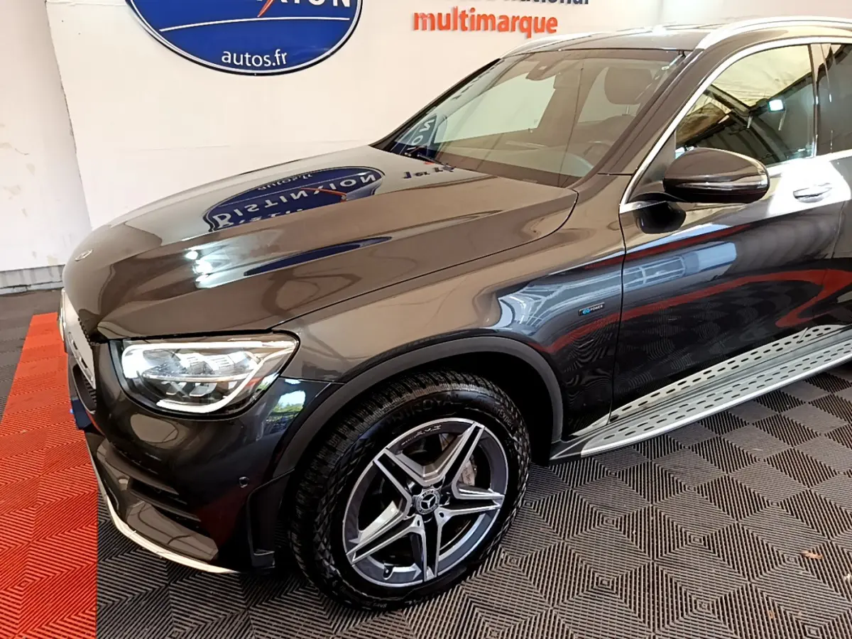 Vue 3/4 avant droit d'un Mercedes GLC 300 E AMG Line gris foncé avec jantes alliage et badge hybride rechargeable.