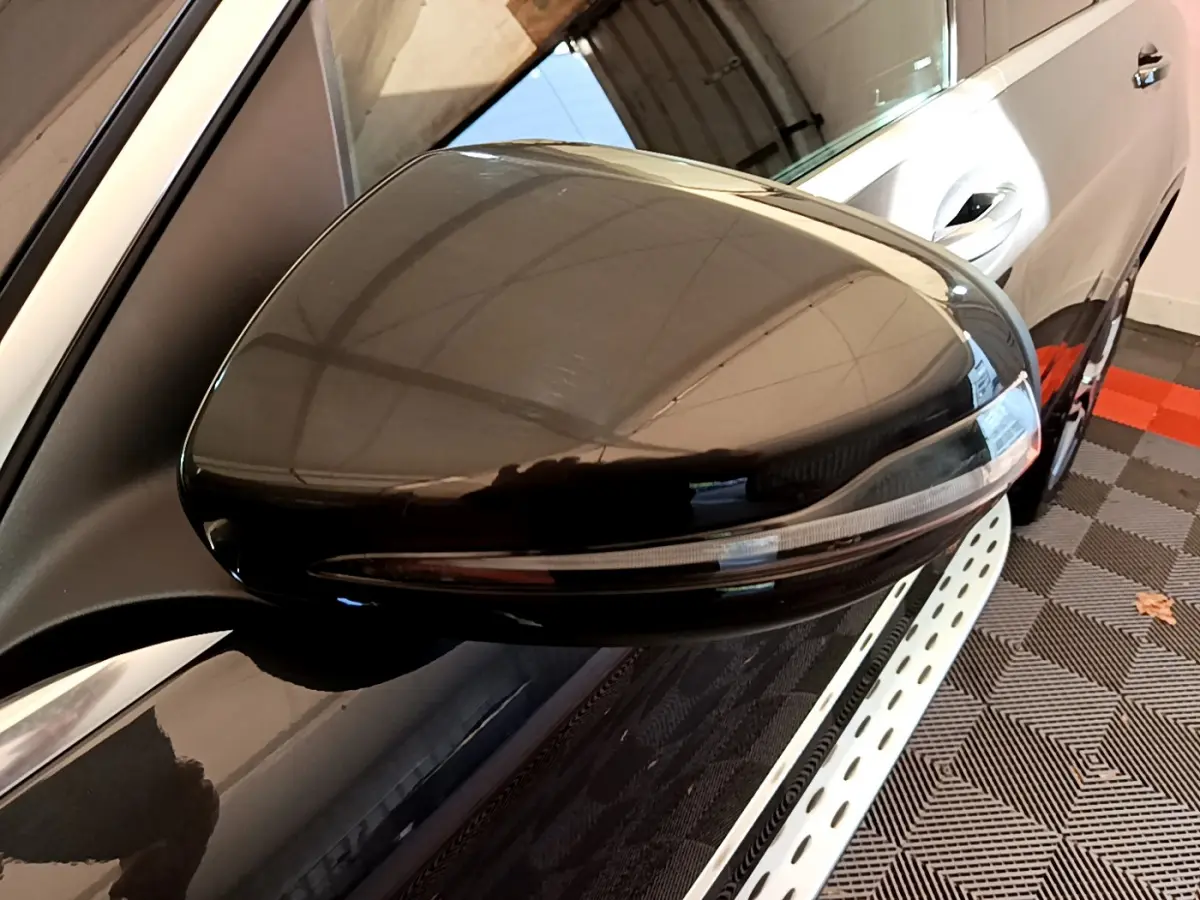 Rétroviseur droit noir brillant du Mercedes GLC 300 E AMG Line 4MATIC gris foncé, vue rapprochée en intérieur.