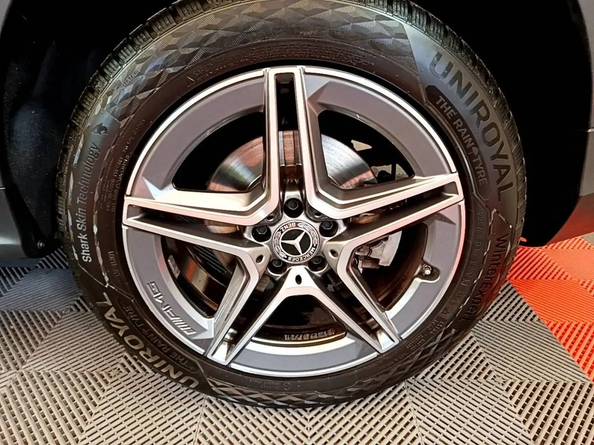 Gros plan sur la jante AMG étoile grise et pneu Uniroyal du Mercedes GLC 300 E AMG Line hybride rechargeable.