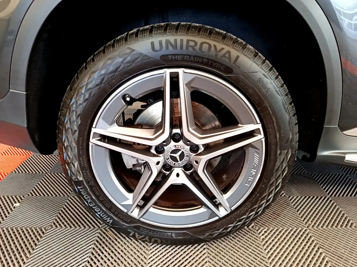 Gros plan sur la roue avant droite gris foncé d'un Mercedes GLC 300 E AMG Line avec jante AMG cinq branches.