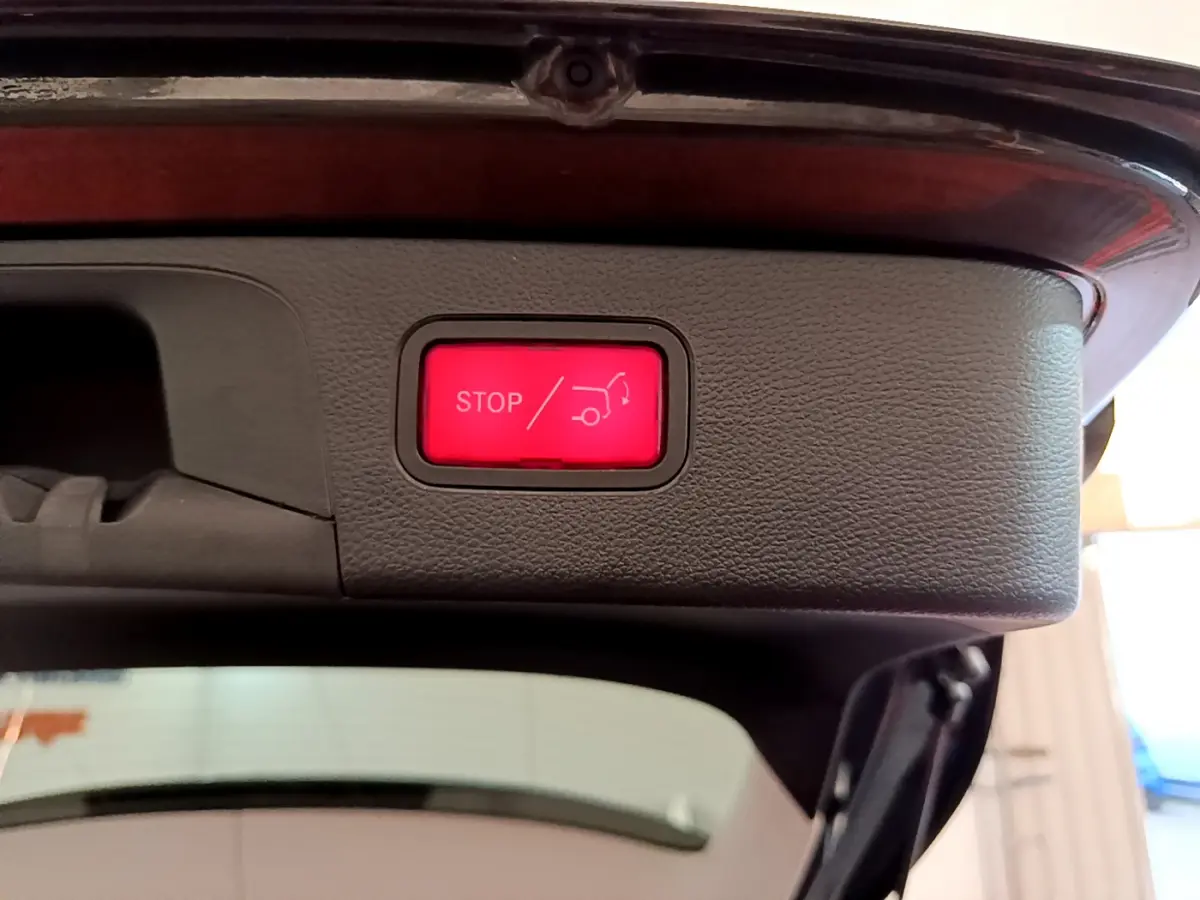 Bouton rouge stop pour fermeture électrique du coffre du Mercedes GLC 300 E AMG Line gris foncé, vue intérieure arrière.