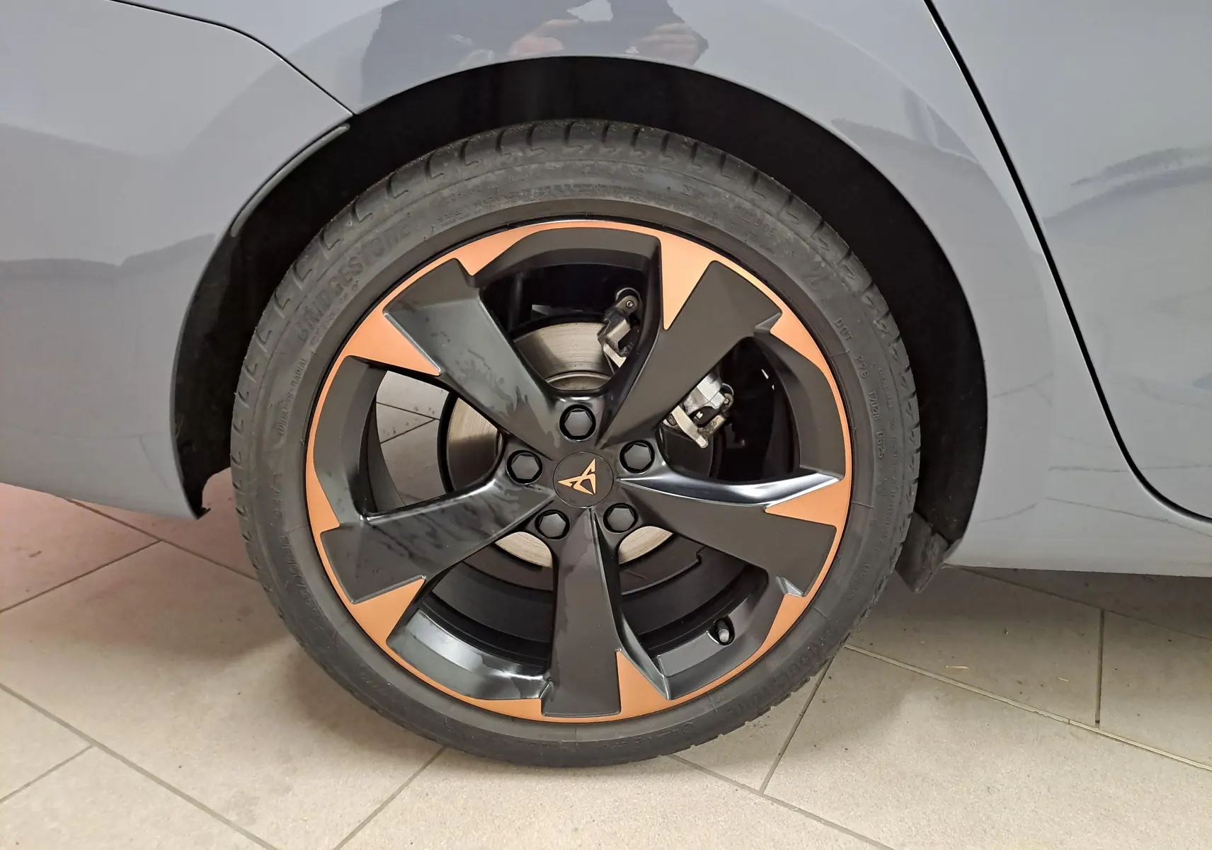 Gros plan sur la jante cuivrée 18'' Performance du côté arrière droit d'une CUPRA Leon ST Gris Graphène.