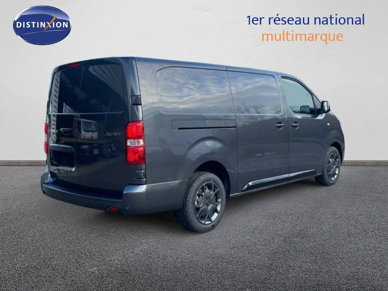 Vue 3/4 arrière droite d’un Citroën Jumpy gris titane métallisé, fourgon utilitaire avec portes latérales et arrière fermées.
