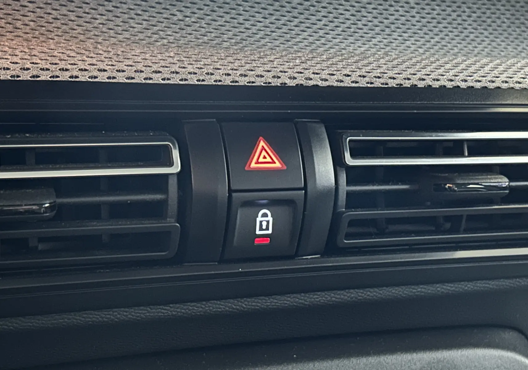 Gros plan sur la console centrale de la Citroën C3 2025 gris Artense, montrant les boutons de warning et de verrouillage des portes.