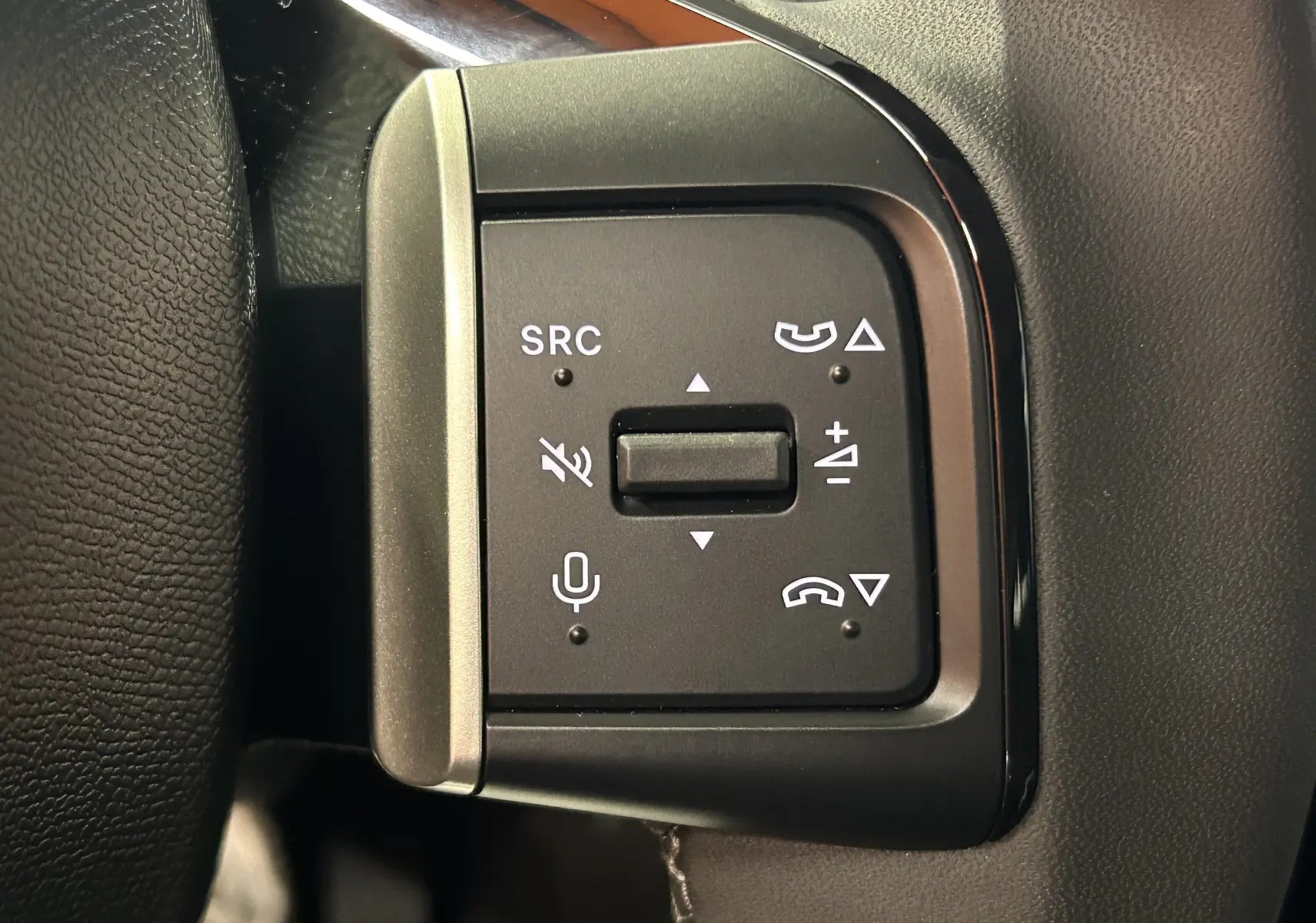 Gros plan sur les commandes multifonctions noires du volant de la Citroën C3 Turbo 100 PLUS gris Artense, version 2025.